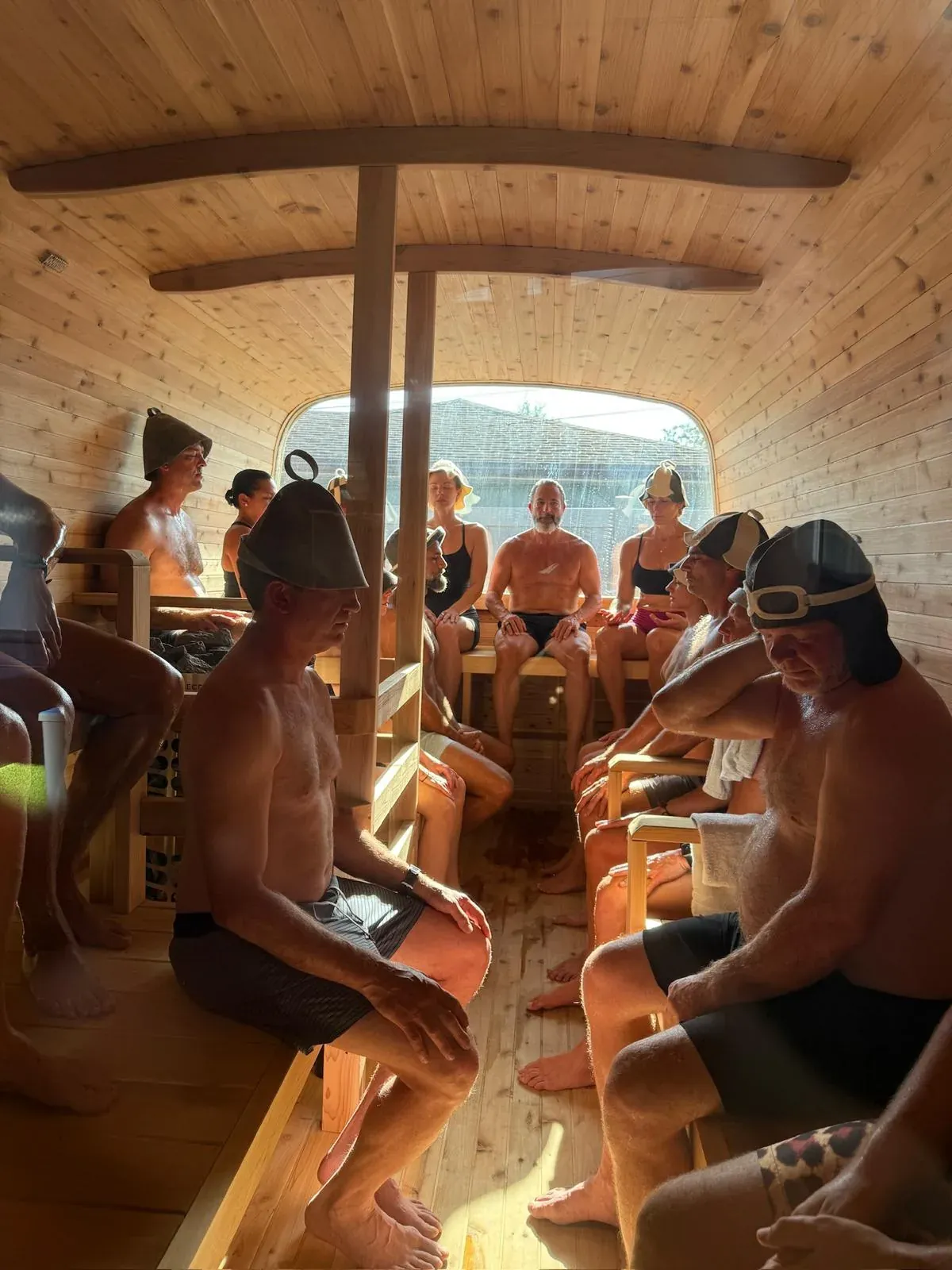 A group beside barrel saunas and a cold plunge at dawn