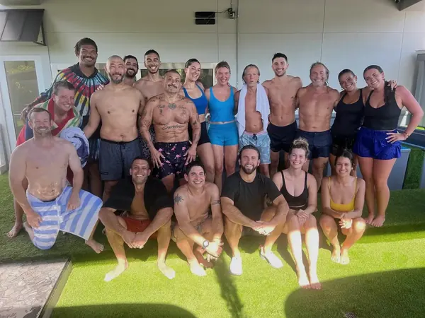A full class of students grouped together on the turf after a sauna and cold plunge session