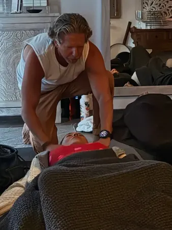Keith coaching a participant through a breath round on the studio floor